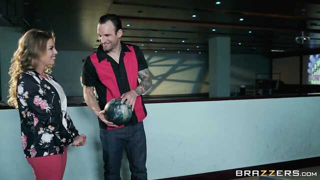 Симпатичная девушка играет в боулинг с парнем.