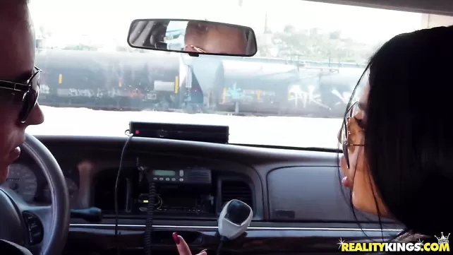 A man in the parking lot is hammering with two prostitutes