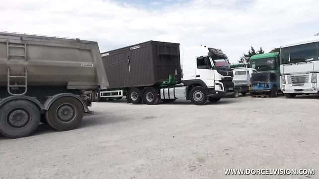 The driver of the truck is hammering in the car with a confused