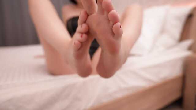Сексуальная милашка в боди возбуждает ступнями