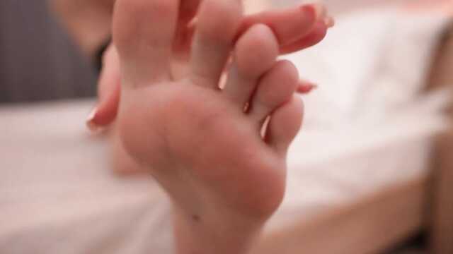 Сексуальная милашка в боди возбуждает ступнями