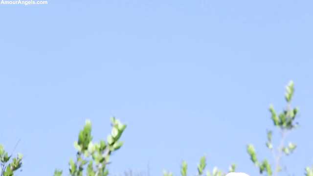 Blondynka w białych pończochach pieści cipkę na łonie natury