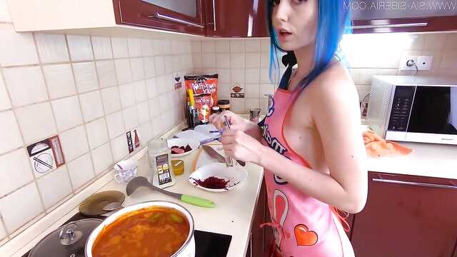 Dziewczyna z niebieskimi włosami na kuchennym stole wali szczelinę ogórkiem