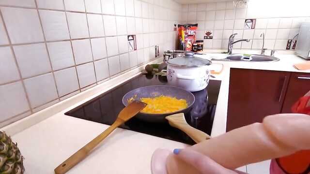 Dziewczyna z niebieskimi włosami na kuchennym stole wali szczelinę ogórkiem